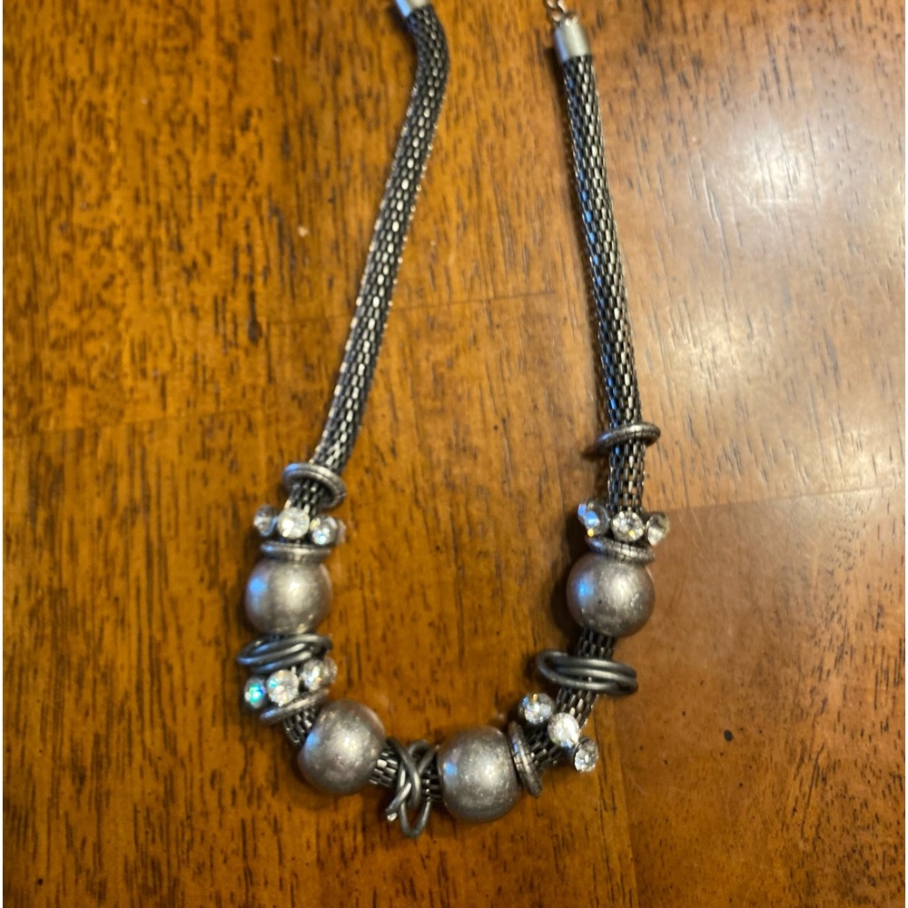 Silver colored rope necklace with rings and rhinestone beads